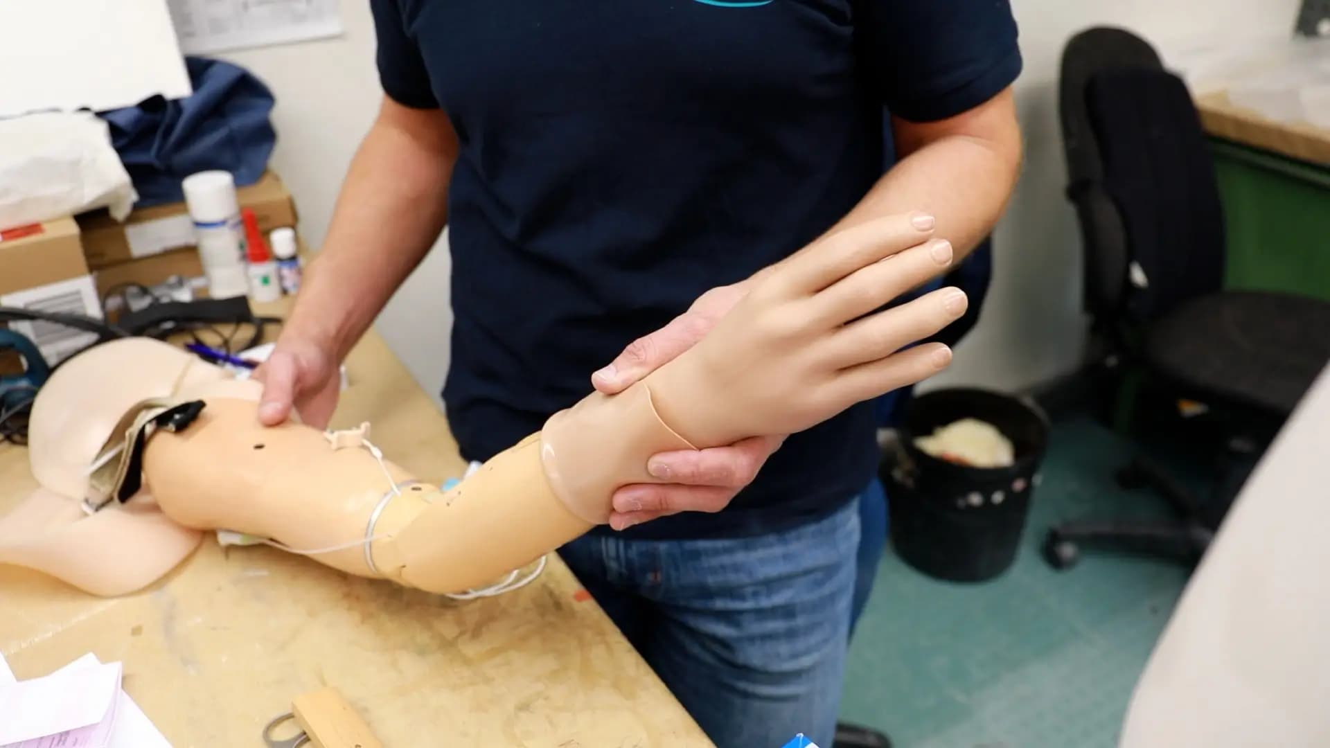Person fertigt Armprothese auf Werkbank Person fertigt Armprothese auf Werkbank