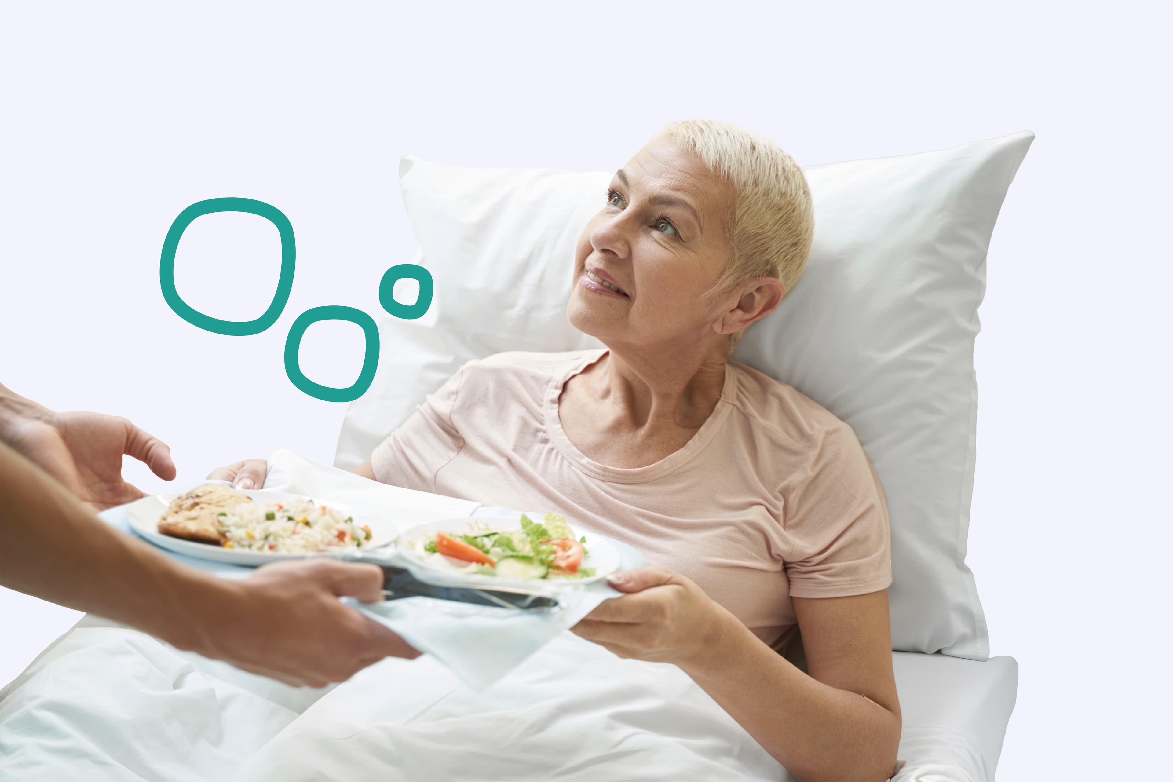 Eine Patientin, die im Bett liegt und ein Tablett mit Essen von einer Pflegekraft gereicht bekommt Eine Patientin, die im Bett liegt und ein Tablett mit Essen von einer Pflegekraft gereicht bekommt