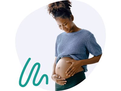 Frau, die ihre Hände auf ihrem Babybauch platziert Frau, die ihre Hände auf ihrem Babybauch platziert