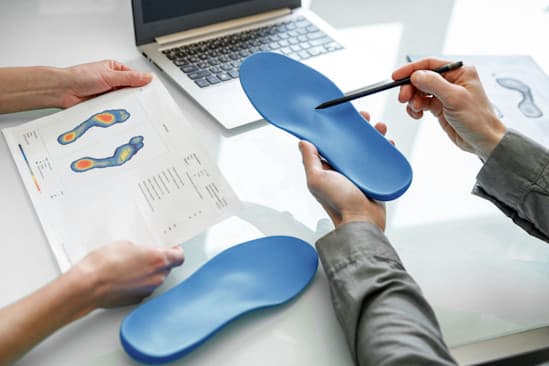 Zwei Personen analysieren fertig Einlagen mit Druckverteilungsgrafik. Zwei Personen analysieren fertig Einlagen mit Druckverteilungsgrafik.